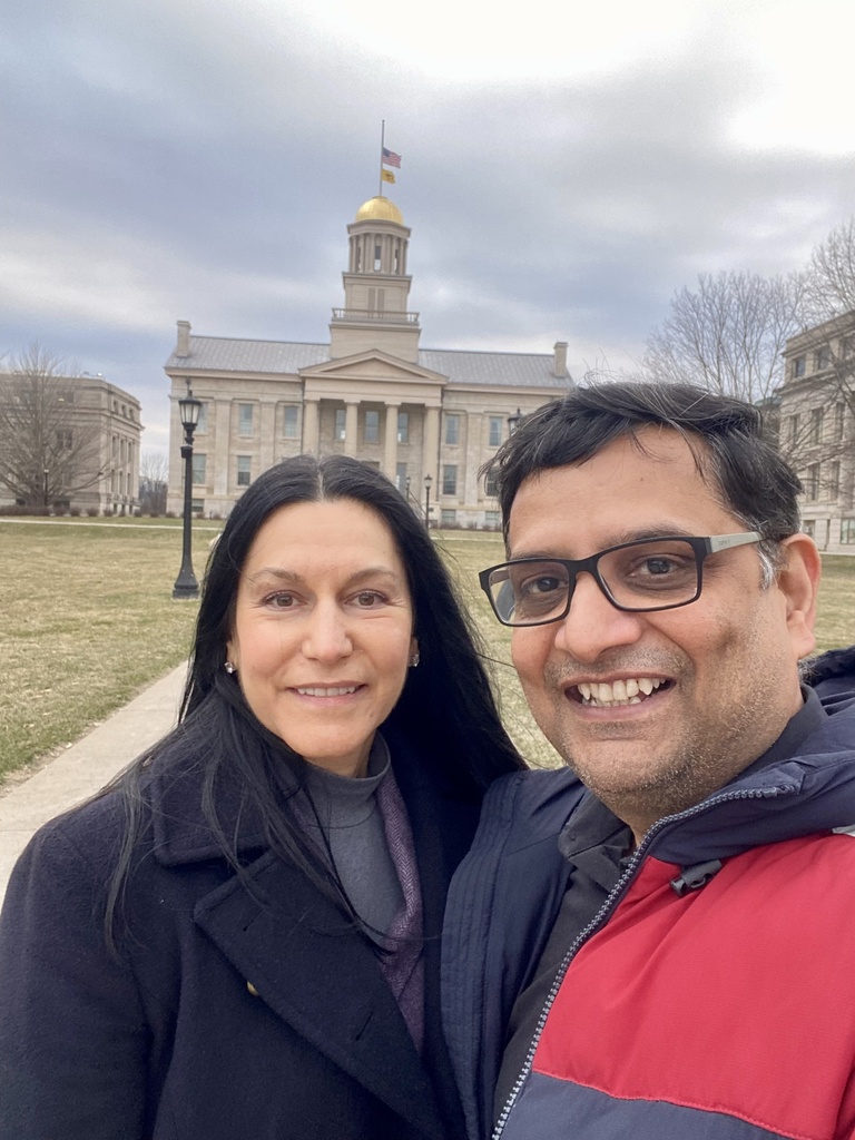 Two people smiling in front of the OId Capitol Building in Iowa City